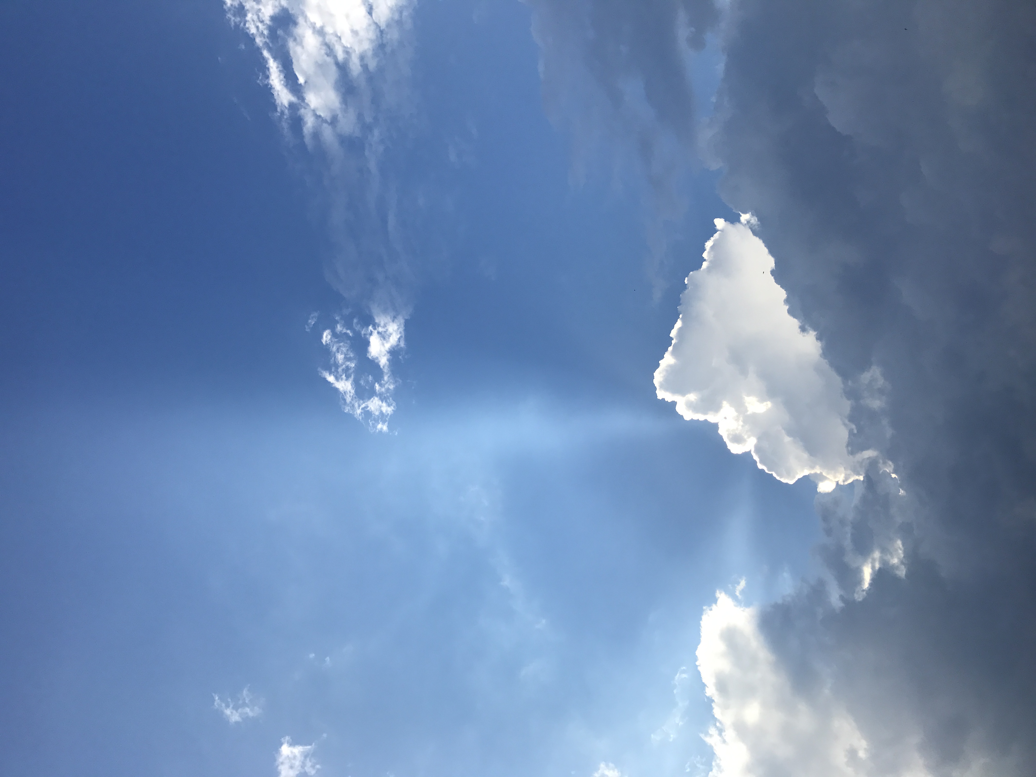 Blue sky with white clouds and a sunbeam